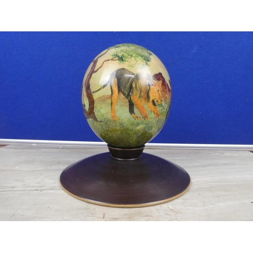 208 - A stunning hand painted ostrich egg decorated with wild animals on a presentation stand.