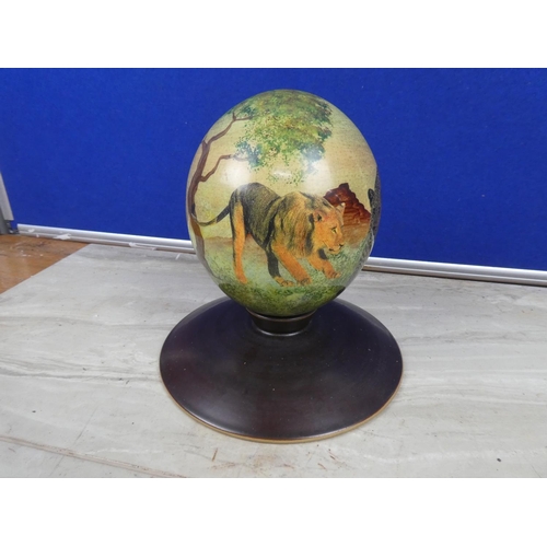 208 - A stunning hand painted ostrich egg decorated with wild animals on a presentation stand.