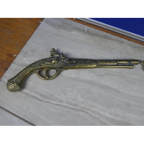 214 - A pair of vintage brass pistol wall plaques.