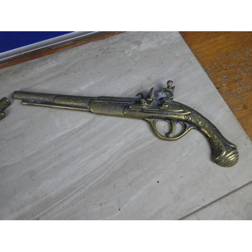 214 - A pair of vintage brass pistol wall plaques.