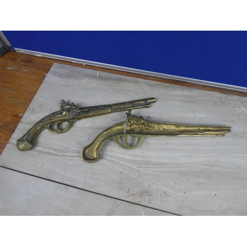 214 - A pair of vintage brass pistol wall plaques.