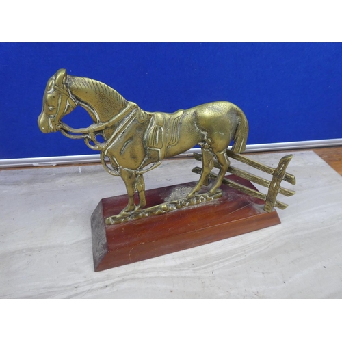 219 - A brass ornament of a horse mounted on a wooden plinth.  Approx 16cm.