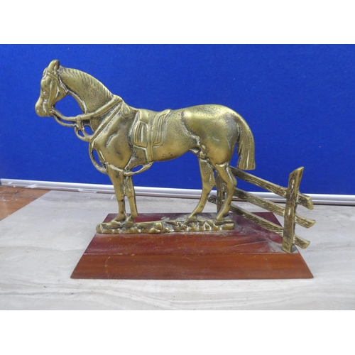 219 - A brass ornament of a horse mounted on a wooden plinth.  Approx 16cm.