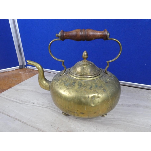 220 - An antique brass teapot with wooden handle.