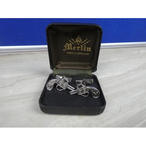 253 - A pair of pistol cufflinks.