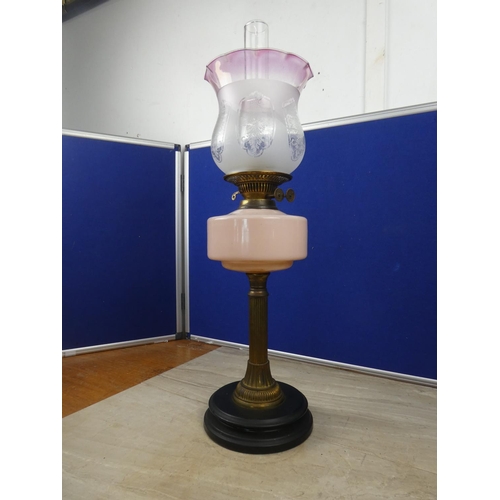 261 - An antique oil lamp with peach glass font and an etched and ruby glass shade.  Approx 65cm.