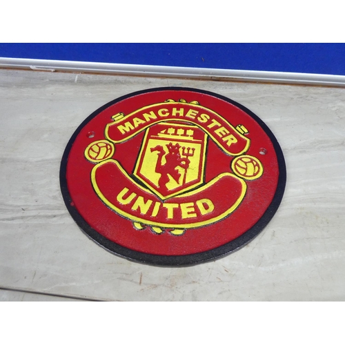 320 - A Manchester United cast iron plaque.  Approx 24cm dia.