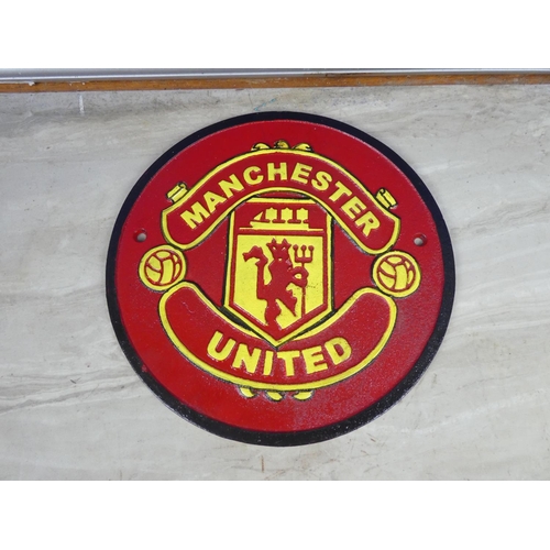 320 - A Manchester United cast iron plaque.  Approx 24cm dia.