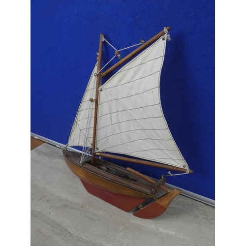 474 - A wooden sail boat with fabric sail.  Approx 30cm.