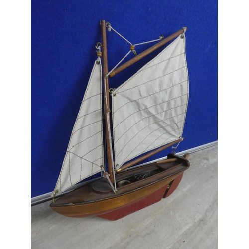 474 - A wooden sail boat with fabric sail.  Approx 30cm.