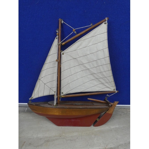 474 - A wooden sail boat with fabric sail.  Approx 30cm.