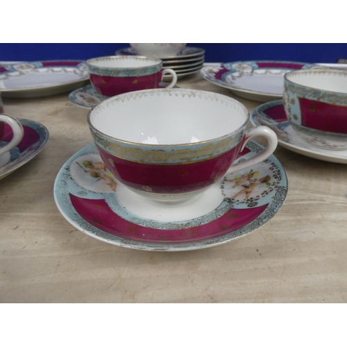 548 - A vintage bone china tea set decorated with cherub figures.