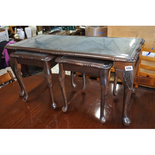 656 - A nest of three tables with glass tops.