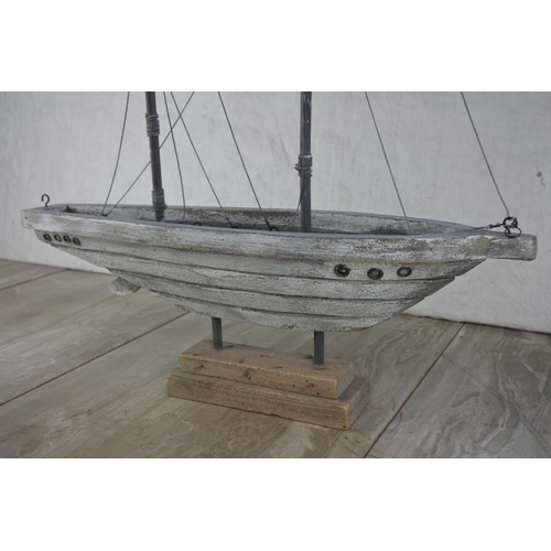 697 - A wooden ornamental boat on stand.