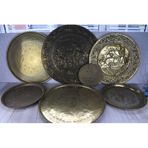 763 - A large lot of assorted brass chargers and more.   Largest approx 63cm dia.