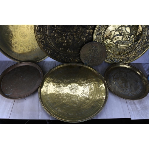 763 - A large lot of assorted brass chargers and more.   Largest approx 63cm dia.