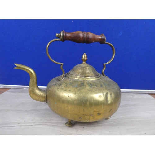 220 - An antique brass teapot with wooden handle.