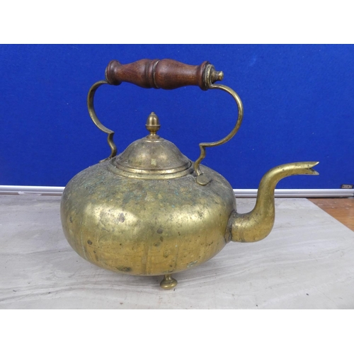 220 - An antique brass teapot with wooden handle.