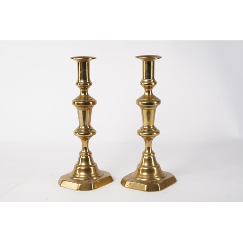 14 - A pair of brass candlesticks, measuring 27cm.