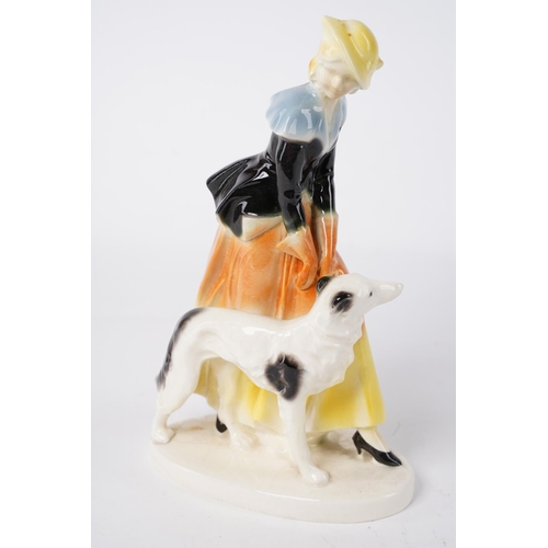 50 - A vintage Art Deco figure of a lady and dog, measuring 22cm.