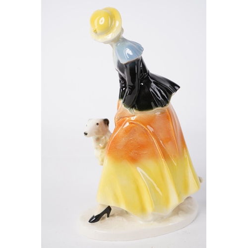 50 - A vintage Art Deco figure of a lady and dog, measuring 22cm.