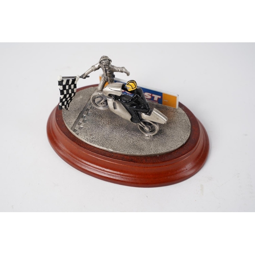 66 - A metal model of a motorbike rider on a wooden plinth, measuring 14cm.