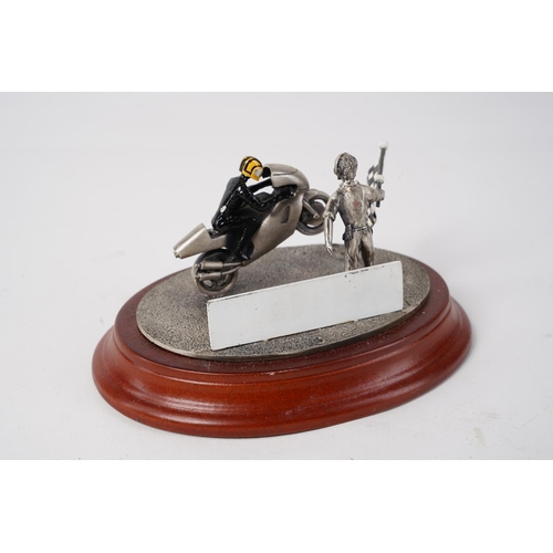 66 - A metal model of a motorbike rider on a wooden plinth, measuring 14cm.