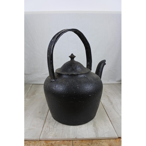 146 - A large antique black kettle with handle repaired, Approx 45cm in height.