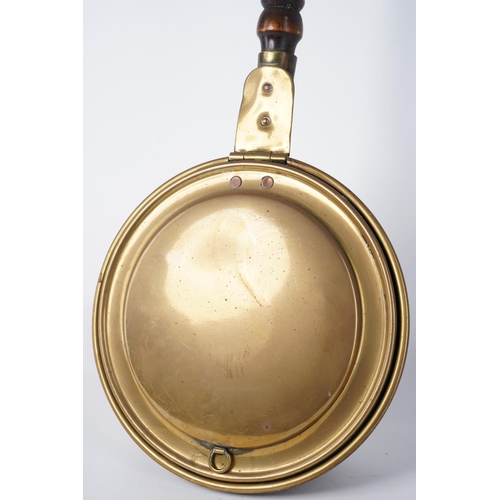 213 - An antique brass bedwarmer with a wooden turned handle, Approx 105cm in length.