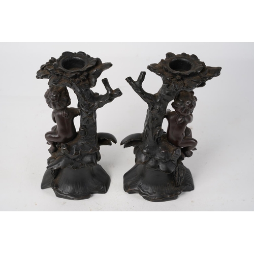 349 - A pair of figurine based candlesticks, measuring 17cm.