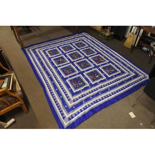 416 - A stunning patterned quilt with embroidery detail.