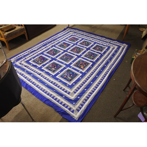 416 - A stunning patterned quilt with embroidery detail.