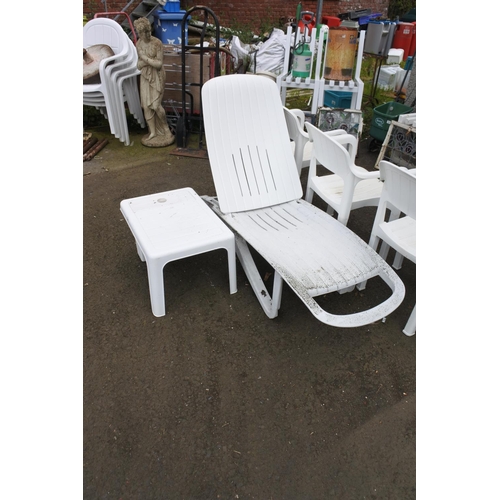 755 - A plastic garden sun lounger and matching table.