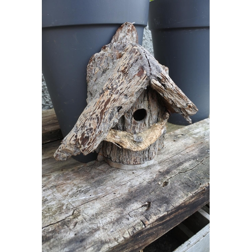 767 - A handmade bird house made from a tree trunk.