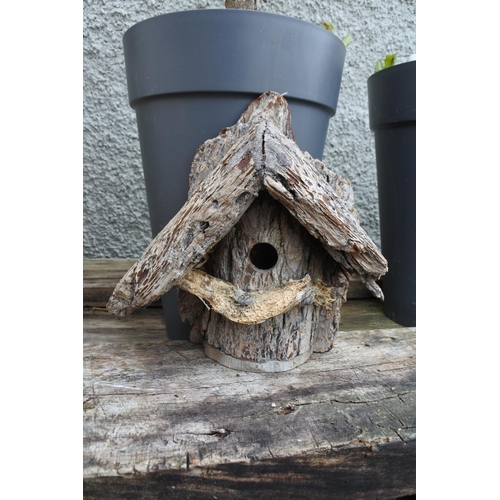 767 - A handmade bird house made from a tree trunk.