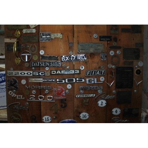 622 - A pine door with a large selection of vintage car badges and mascots.