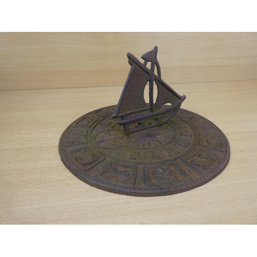 15 - A cast iron sundial with ship detail, measuring 26cm in diameter.