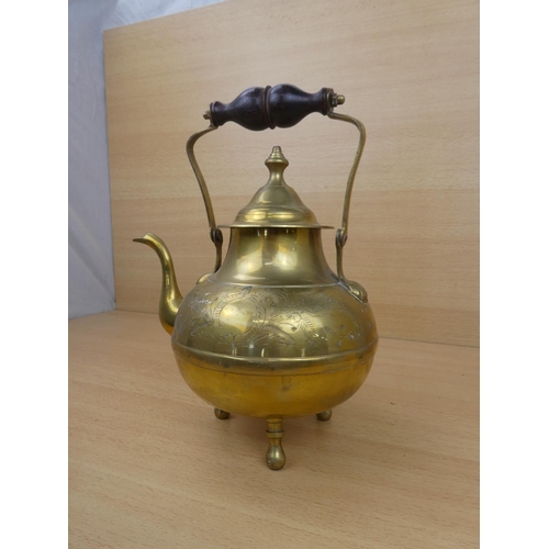 23 - A vintage brass teapot with wooden handle.