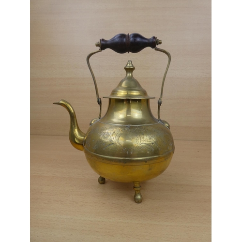 23 - A vintage brass teapot with wooden handle.