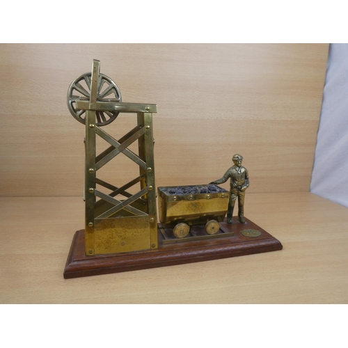 69 - A large brass display of a mining scene and figure.