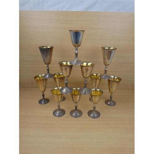 90 - Two sets of six silverplated and gilt goblets.