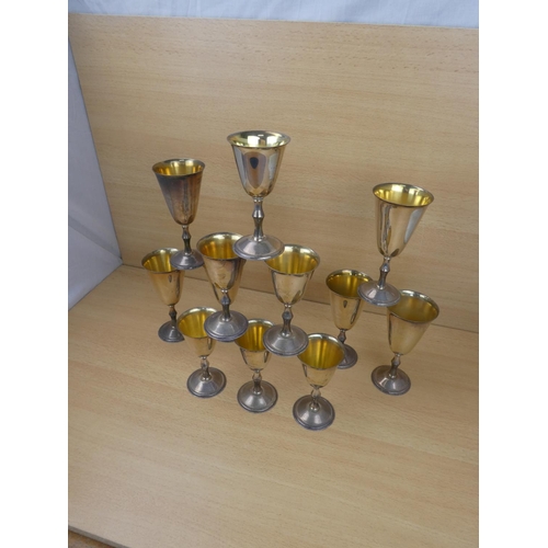 90 - Two sets of six silverplated and gilt goblets.