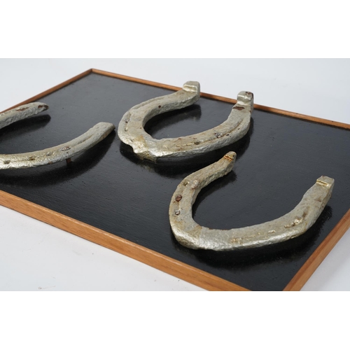 359 - Three mounted horseshoes.