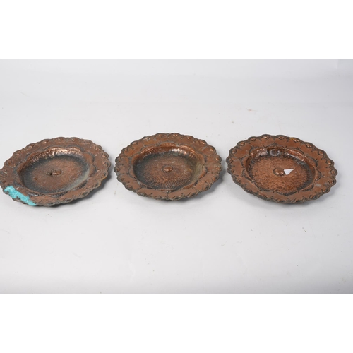 512 - A set of three antique copper beaten and engraved plates, 19cm diameter.