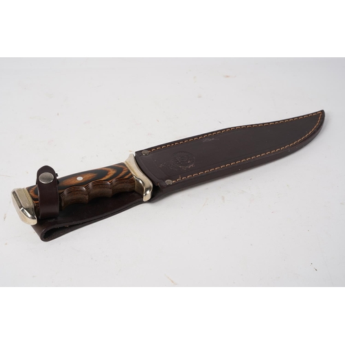 884 - A large Nieto, Spain steel knife and leather sheath.