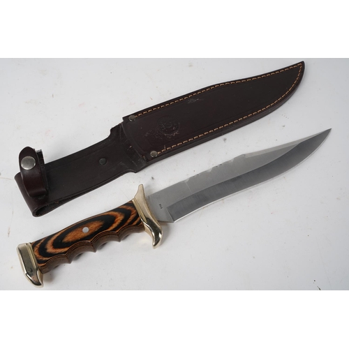 884 - A large Nieto, Spain steel knife and leather sheath.