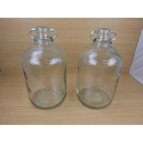 508 - Two clear glass demijohn bottles.