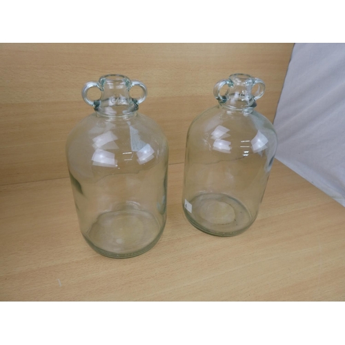 508 - Two clear glass demijohn bottles.