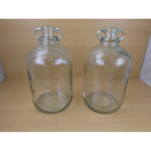 508 - Two clear glass demijohn bottles.