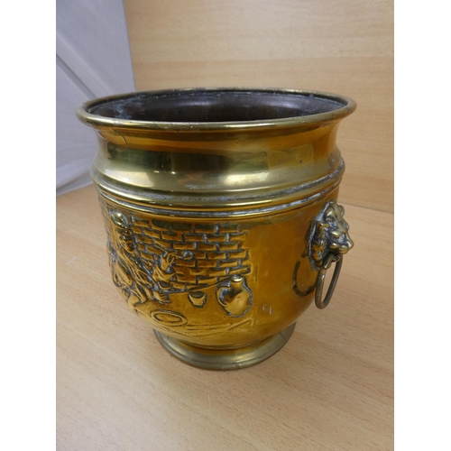 513 - A vintage brass plant pot with lion mask handles.